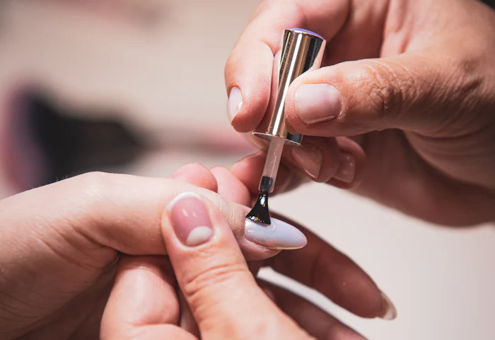 Pose de vernis semi-permanent nude par une prothésiste ongulaire